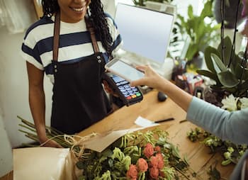 woman paying with phone for flower arrangement