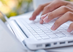 Hands typing a sleek keyboard