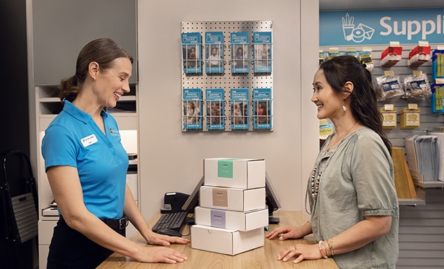 The UPS Store associate helping a customer with packages. 