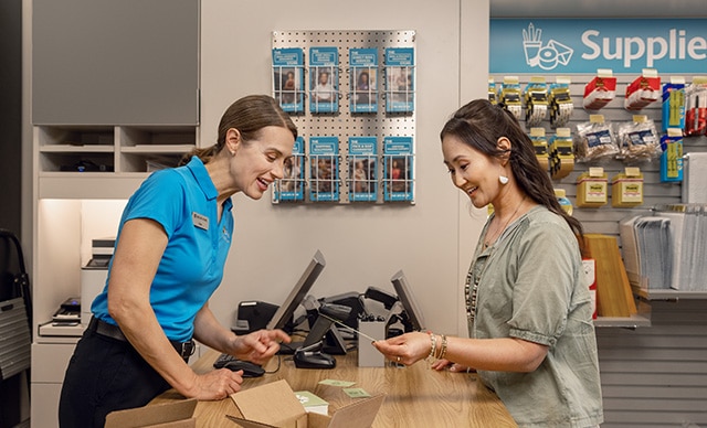 The UPS Store associate showing a customer her custom printed businesss cards